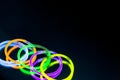 Colorful fluorescent light neon glow stick bracelet strap wristband on mirror reflection black background