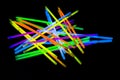 Colorful fluorescent light neon big glow stick on mirror reflection black background