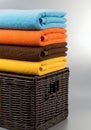 Colorful folded towels stacked on a woven wicker basket Royalty Free Stock Photo
