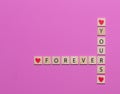 Colorful Forever Yours game tiles laid out on a pink background