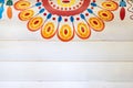 A colorful fragment of the Russian pattern in the style of Dymkovo on wooden wall painted in white