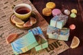 Colorful, fragrant handmade soap , a cup of tea and various sweets. Royalty Free Stock Photo