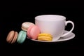 Colorful French Macarons with Cup of Tea over black
