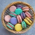 Colorful french pastel cake macaron cookies or macaroon on a wicker basket.