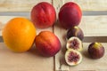 Colorful fresh fruits - oranges, figs and peaches lie on a wooden box. Royalty Free Stock Photo