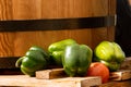 Colorful fresh juicy peppers on a wooden barrel