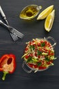 Colorful fresh vegetable salad in a glass bowl on a black wooden table. Vegetarian salad of cabbage, sweet pepper and Royalty Free Stock Photo