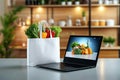 Colorful fresh vegetables in white bag and on laptop in modern kitchen setting Royalty Free Stock Photo