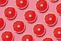 Colorful fruit pattern of fresh grapefruit slices on pink background