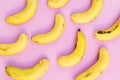Colorful fruit pattern of fresh yellow bananas on pink background Royalty Free Stock Photo