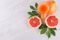 Colorful fruit pink juice with grapefruits and green leaves as fresh healthy summer background. Royalty Free Stock Photo