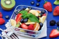 Colorful fruit salad in a bowl on a wood table Royalty Free Stock Photo