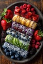 Colorful Fruit Sushi Rolls on Dark Wooden Plate Royalty Free Stock Photo