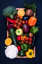 Colorful fruits and vegetables in a wooden box on a dark background Royalty Free Stock Photo