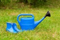 Colorful garden tools on a green lawn. watering can and rubber boots. Royalty Free Stock Photo