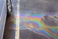 Colorful gas stain on wet asphalt. Oil stain caused by a leak under a car Royalty Free Stock Photo