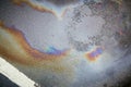 Colorful gas stain on wet asphalt. Oil stain caused by a leak under a car or truck Royalty Free Stock Photo