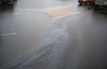 Colorful gas stain on wet asphalt. Oil stain caused by a leak under a car or truck Royalty Free Stock Photo