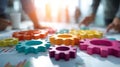Colorful gears being joined on a table under bright sunlight in a creative workspace Royalty Free Stock Photo
