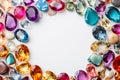 Colorful gems on white. Colorful Sapphires, ruby, amethyst, topaz, emerald gemstones scattered on a white background with empty Royalty Free Stock Photo