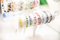 Colorful gemstone bracelets on a white stand with a blurred background