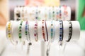 Colorful gemstone bracelets on a white stand with a blurred background