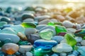 Colorful gemstones on a beach. Polish textured sea glass and stones on the seashore. Green, blue shiny glass with multi-colored Royalty Free Stock Photo