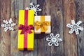 Colorful gift boxes with bows and snowflakes over wooden backgr Royalty Free Stock Photo