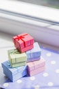 Colorful gift boxes on spotted fabric near window
