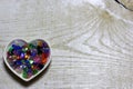 Colorful glass beads hearts on wooden background. Royalty Free Stock Photo