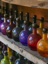 Colorful glass bottles on a wooden shelf Royalty Free Stock Photo