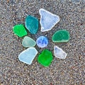 Colorful glass pieces on wet sand beach Royalty Free Stock Photo