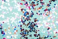 Colorful glitter confetti on abstract mint background. Shiny holiday background.