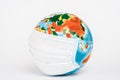 Colorful globe in medical mask on
