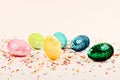 Colorful glossy easter eggs with sequins.Vivid pastry topping on the pastel background.Festive background.Free space for text