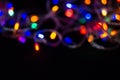 Colorful bokeh from a defocused garland on a black background Royalty Free Stock Photo