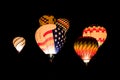 Colorful glowing hot air balloons flying at night against a black background of night sky Royalty Free Stock Photo