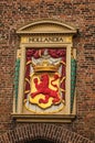 Colorful and golden coat of arms from royalty decorating brick wall at The Hague.