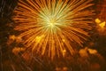 Colorful golden firework bursting exploding in dark sky. Flying sparks of holiday fireworks, colored smoke and bright