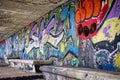 Colorful graffiti spray-painted on an urban wall in an underpass tunnel
