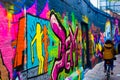 Colorful graffity in Werregarenstraat Graffiti Street in Ghent, Belgium, Europe, with defocused background with a person on a