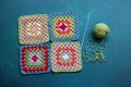 Rainbow colored Afghan squares on a table. Multicolored vintage ornament. Hippie fashion concept.