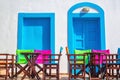 Colorful Greek restaurant table and chairs in front of iconic bl Royalty Free Stock Photo