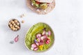 Colorful green hummus bowl with baked radish and edible flowers, falafel and pita flat bread, vegetarian meal