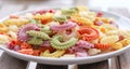 Colorful green, yellow, white, orange and pink italian crown pasta on white plate, close-up.