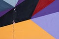 Colorful grey, purple, yellow, red and black painted wall with cracks