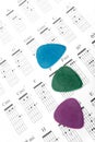 Colorful guitar picks on a chords chart