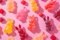 Colorful gummy bunnies scattered with a dusting of sugar on a playful pink background