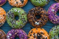 Colorful Halloween donuts with sprinkles with sugar eyes, full frame, flat lay Royalty Free Stock Photo