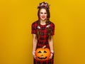 Happy woman on yellow background holding jack-o-lantern pumpkin Royalty Free Stock Photo